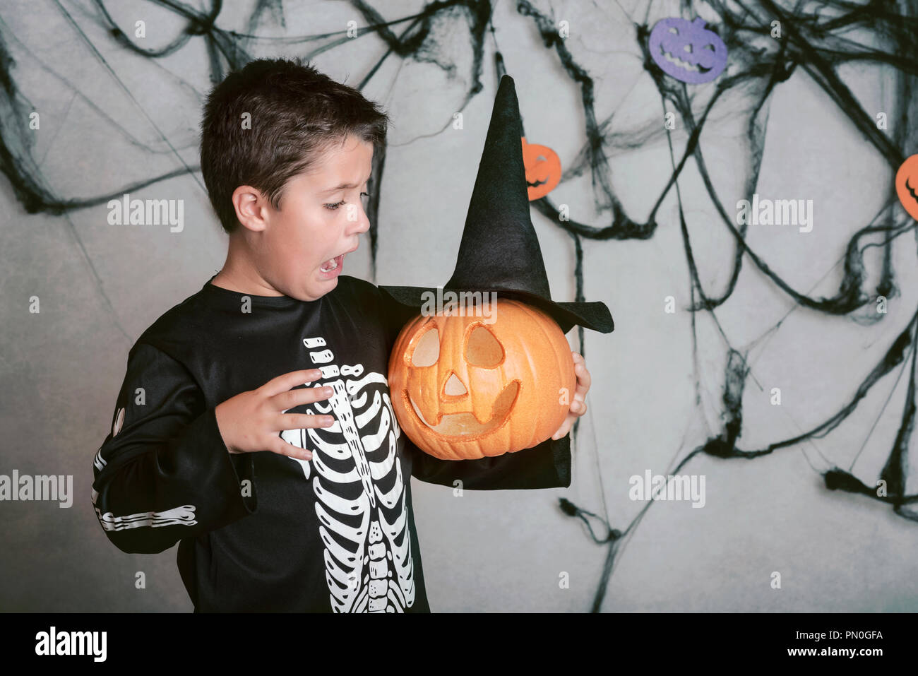 Bambino sorpreso con zucca di Halloween Foto Stock