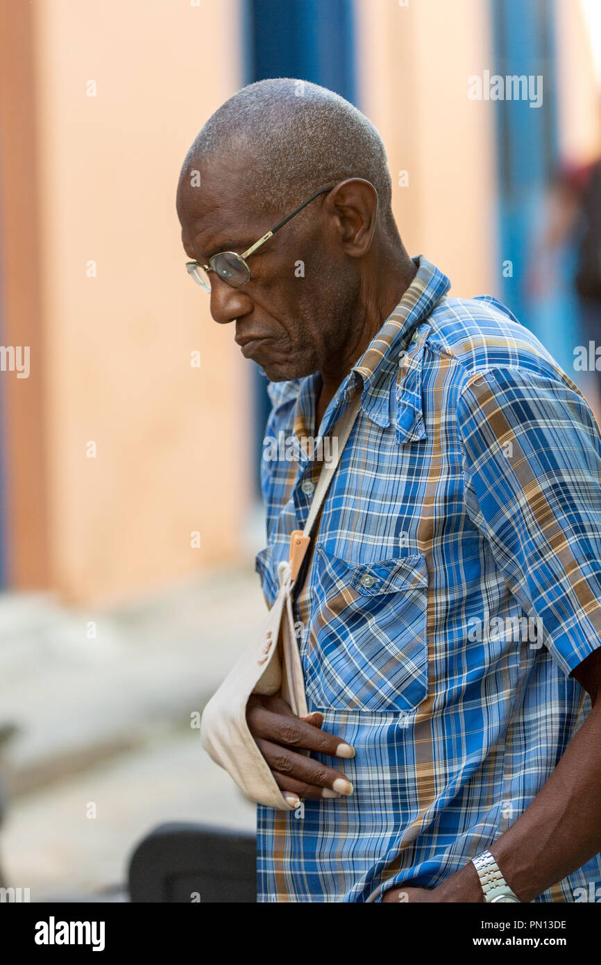 Cuba orologi uomo gioco di domino su strada, Havana, Cuba Foto Stock