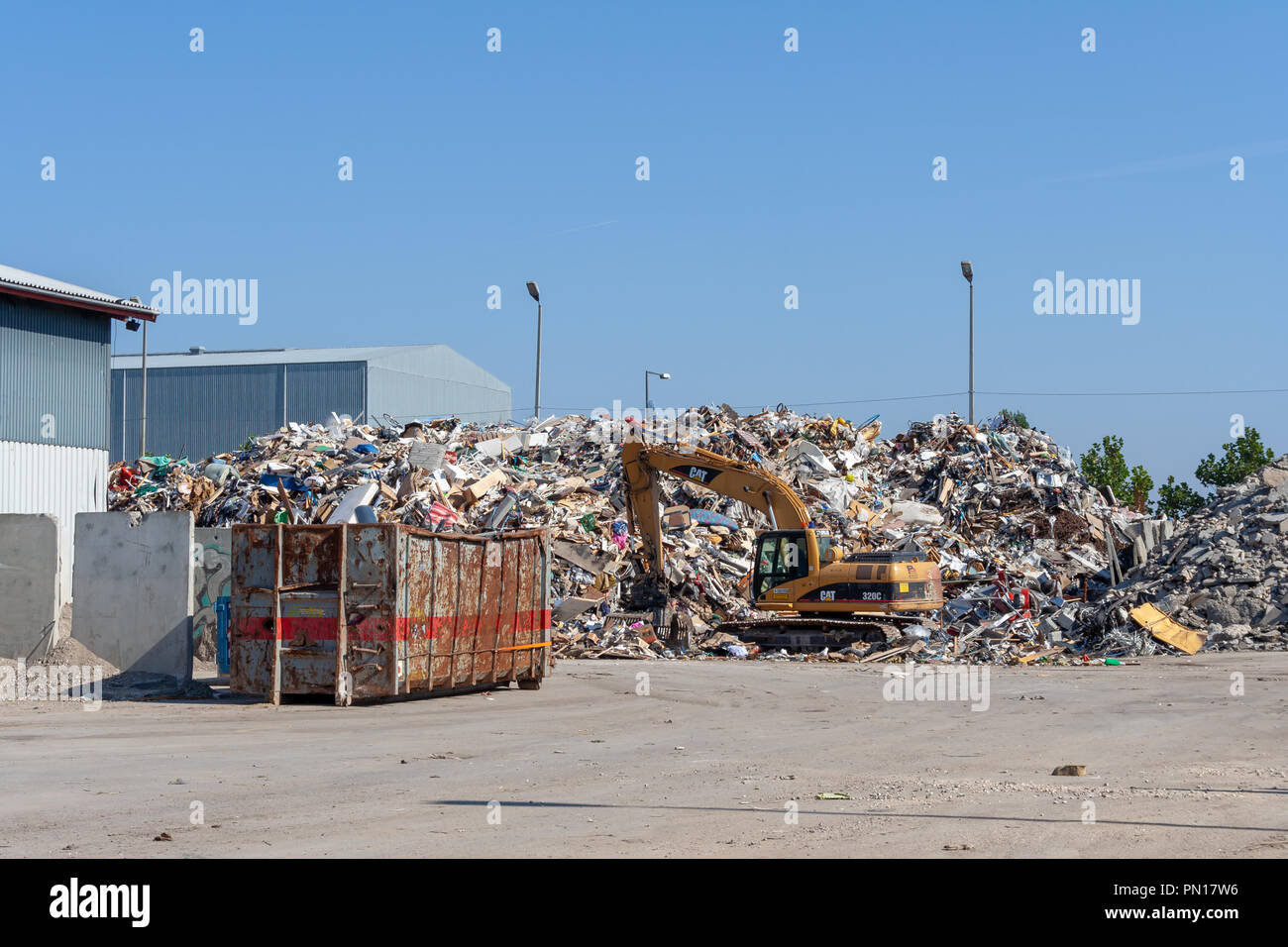 Un enorme cumulo di rifiuti, potenza di pala e cassonetto Foto Stock