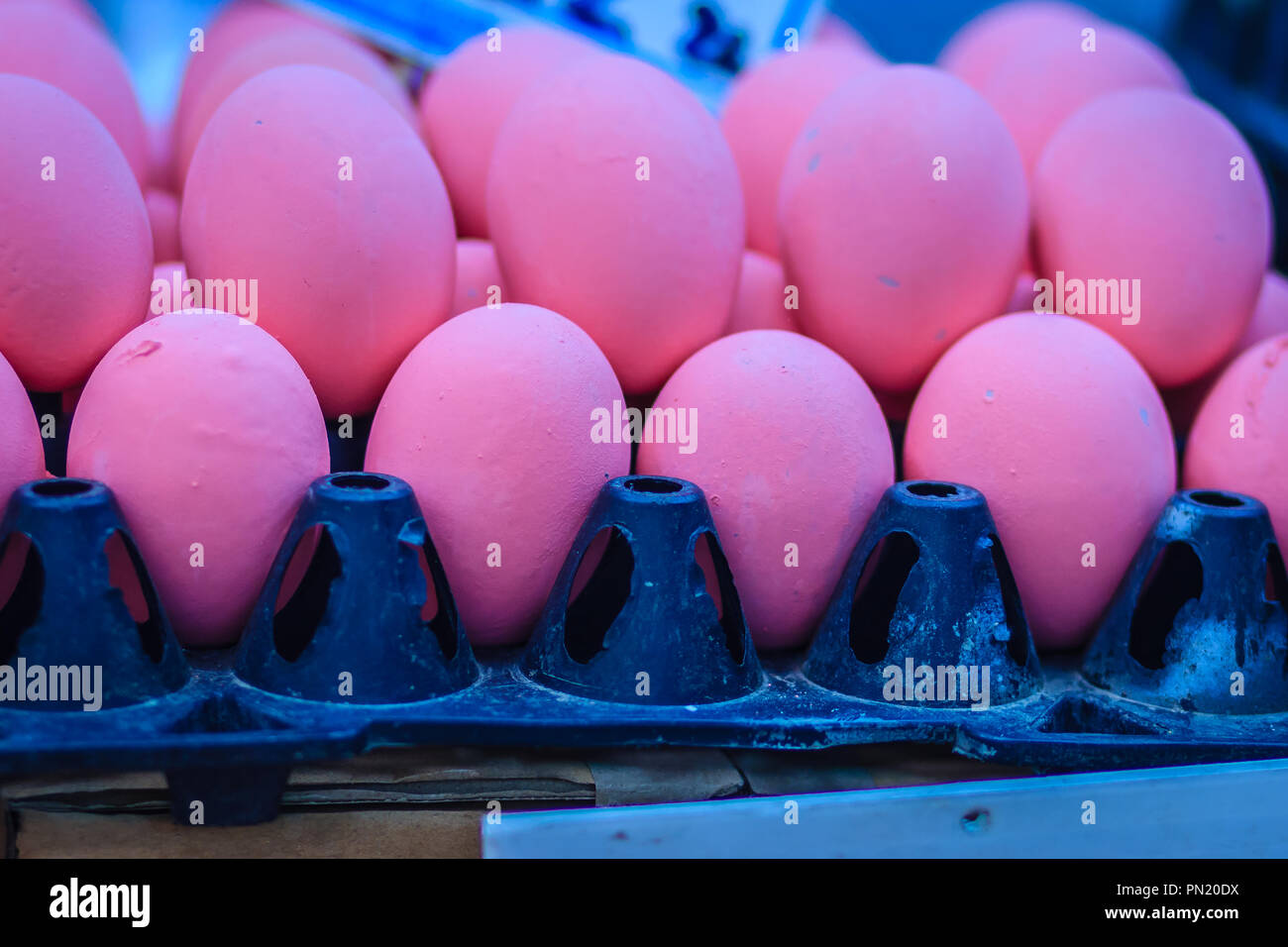 Rosa secolo le uova per la vendita al mercato dei prodotti freschi. Secolo di uova o pidan uova fatte da preservare l'Anatra di pollo o di uova di quaglia miscelato di cenere, sale, calce rosso Foto Stock