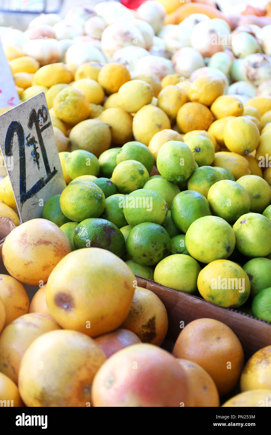 Un mucchio di limone e la calce e agrumi sono su un tavolo esterno display per la vendita in un piccolo borgo contadino di mercato. Foto Stock