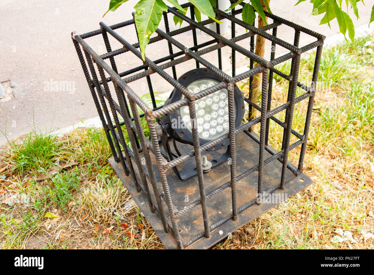 Un lampione all'interno di un anti-vandalo griglia. Foto Stock