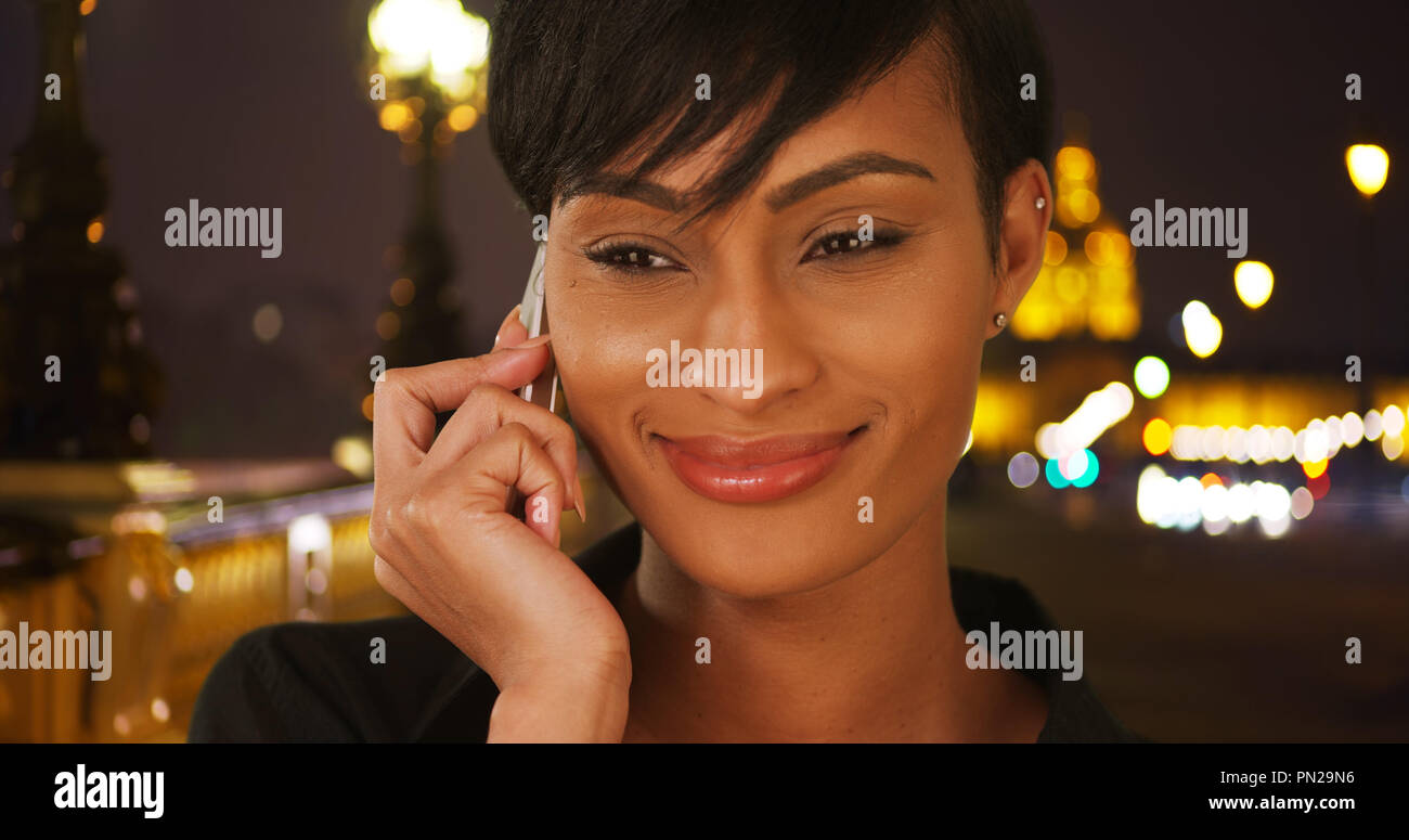 Bella giovane etnica lady sul Pont Alexandre III parla con un amico sul telefono Foto Stock