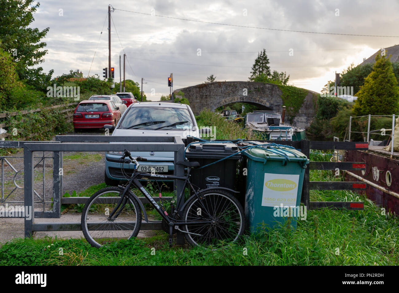 Auto, Moto e scomparti sulla riva dalle case galleggianti di attracco presso il Grand Canal in Hazelhatch, sud della contea di Dublino, Irlanda Foto Stock
