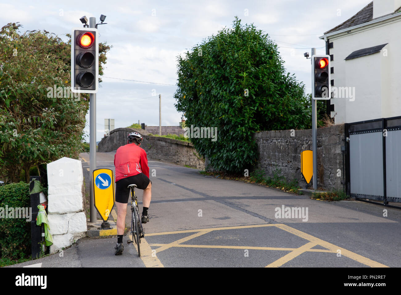 Ciclista al semaforo sullo stretto ponte Hazelhatch Hazelhatch nel sud della contea di Dublino Foto Stock