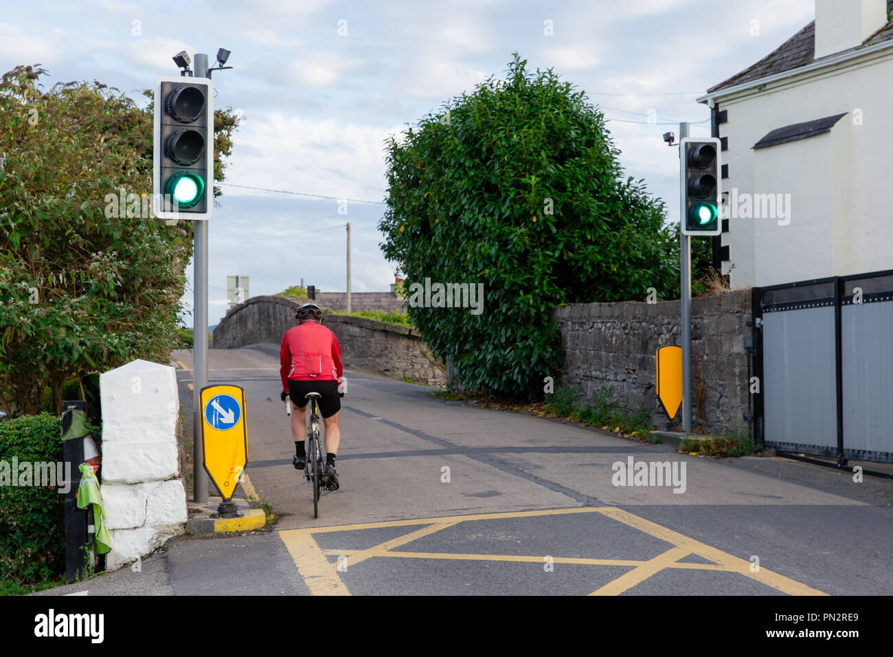 Ciclista al semaforo sullo stretto ponte Hazelhatch Hazelhatch nel sud della contea di Dublino Foto Stock