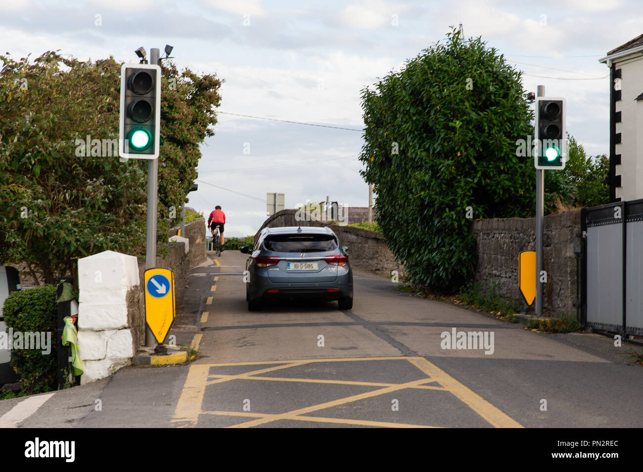 Auto e il ciclista che attraversa lo stretto ponte Hazelhatch in Hazelhatch, sud della contea di Dublino vicino a Celbridge in Irlanda. Foto Stock