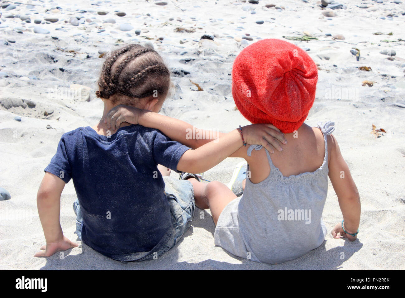 Twin toddlers seduta nella sabbia Foto Stock