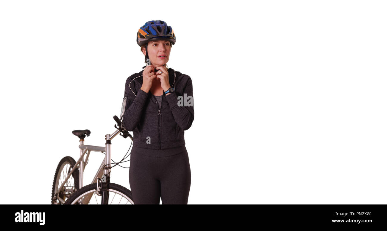 Di mezza età donna caucasici in usura atletica in piedi con la bicicletta Foto Stock