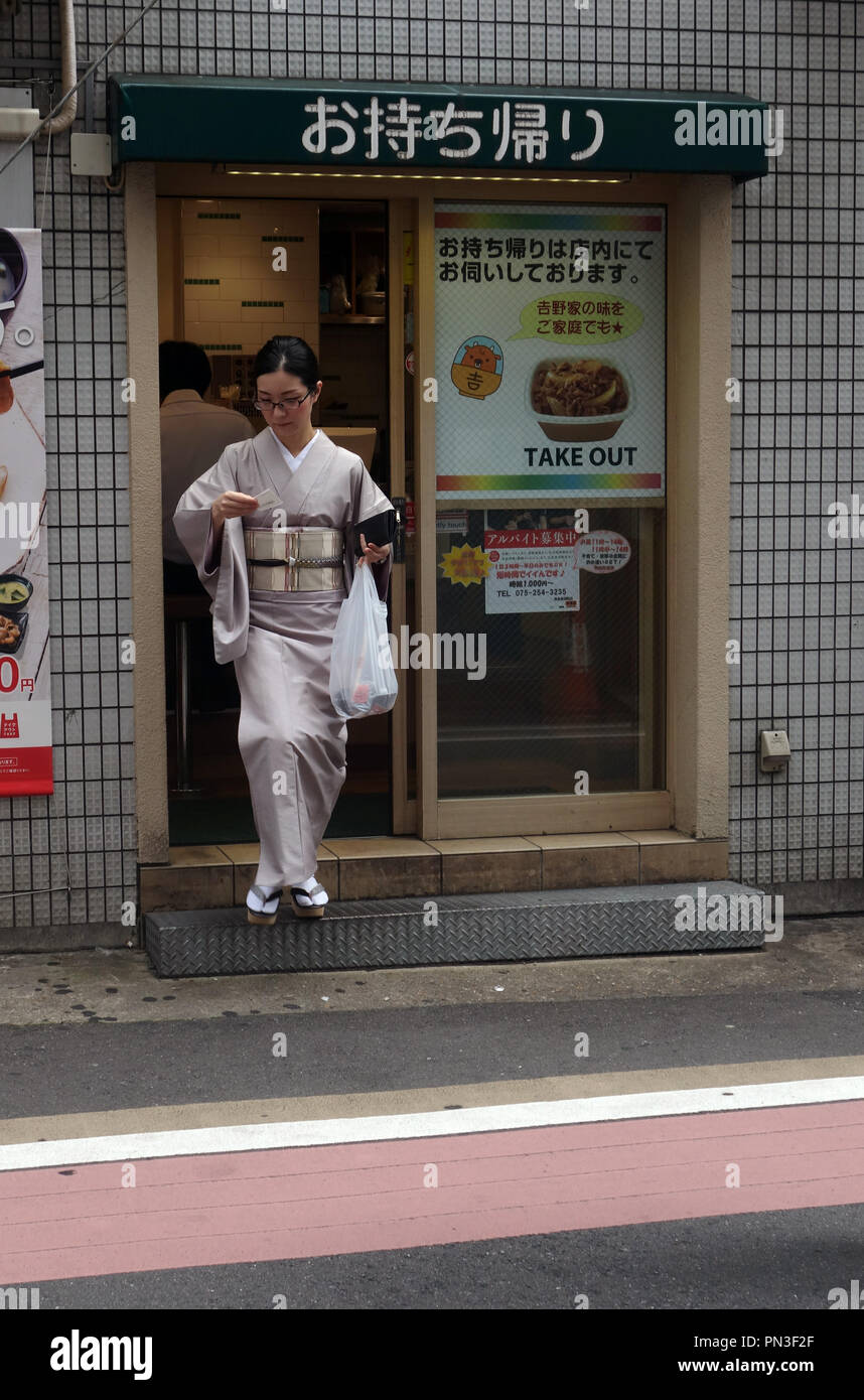 Donna in kimono getting takeway cibo, Kyoto, Giappone. No signor o PR Foto Stock