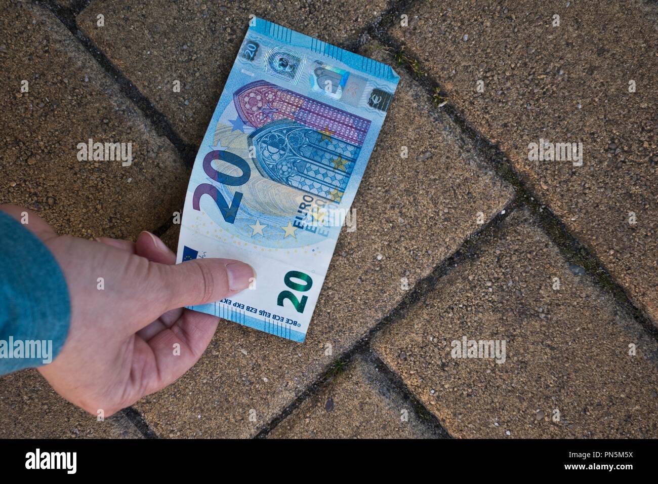 Ricerca di un 20 di banconote in euro sul terreno Foto Stock