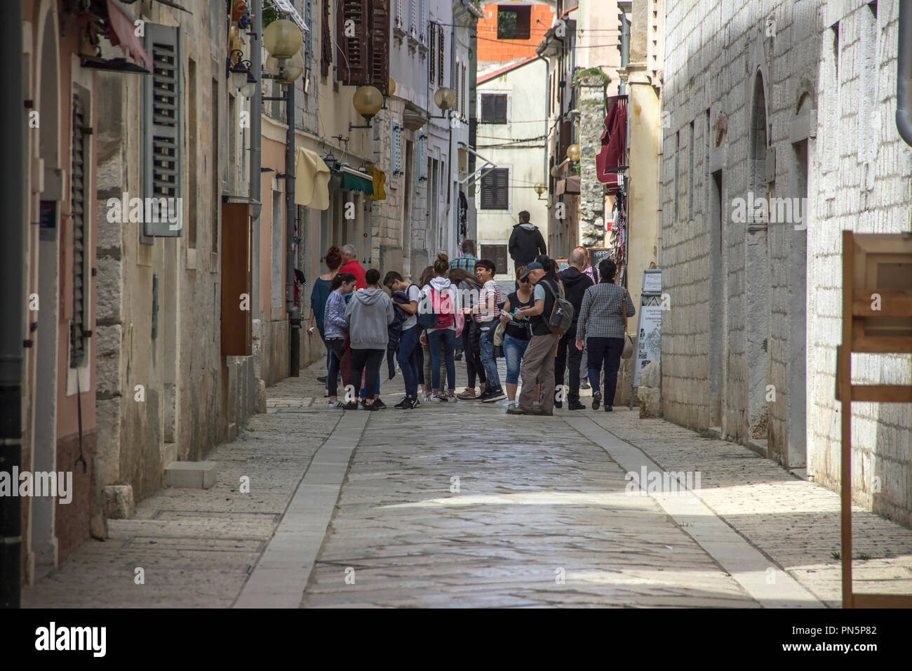 Istria, Croazia, Aprile 2018 - i turisti e i locali a piedi giù per la strada di ciottoli nel centro storico di Porec Foto Stock