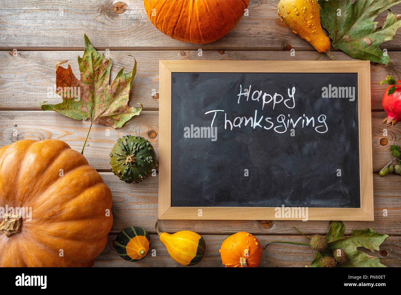 Felice ringraziamento. Zucche colorate, frutta e lavagna vuota su legno rustico sfondo, testo, vista dall'alto Foto Stock