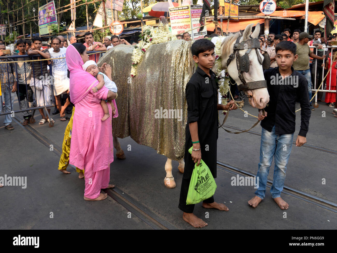 Kolkata, India. Xix Sep, 2018. Indiano musulmano sciita donne toccare un simbolico cavallo di sacro e di pregare con i suoi figli per buona fortuna durante una processione precedendo di Muharram. Indiano musulmano sciita prendere parte in una processione durante i dieci giorni di lutto periodo fino a Ashura, commemora la morte dell imam Hussein che fu ucciso dagli eserciti del rivale Yazid vicino Karbal in 680annuncio. Credito: Saikat Paolo/Pacific Press/Alamy Live News Foto Stock