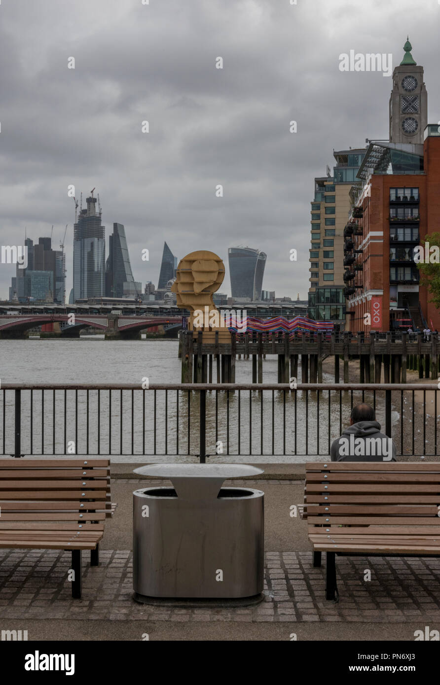 Londra, Regno Unito. Xx Settembre 2018. La skyline di Londra e installazioni di arte alla giunzione di design, parte della London Design Festival sulla riva sud del fiume Tamigi in centro a Londra presso la torre di osso. La colorata 'gateway per inclusione' e la scultura in legno "testa sopra l'acqua elevare il profilo delle questioni concernenti la salute mentale nel Regno Unito. Una tipica giornata autunnale con il grigio nuvole sopra la città di Londra fornisce lo sfondo e lo skyline in un suggestivo paesaggio di Londra. Foto Stock