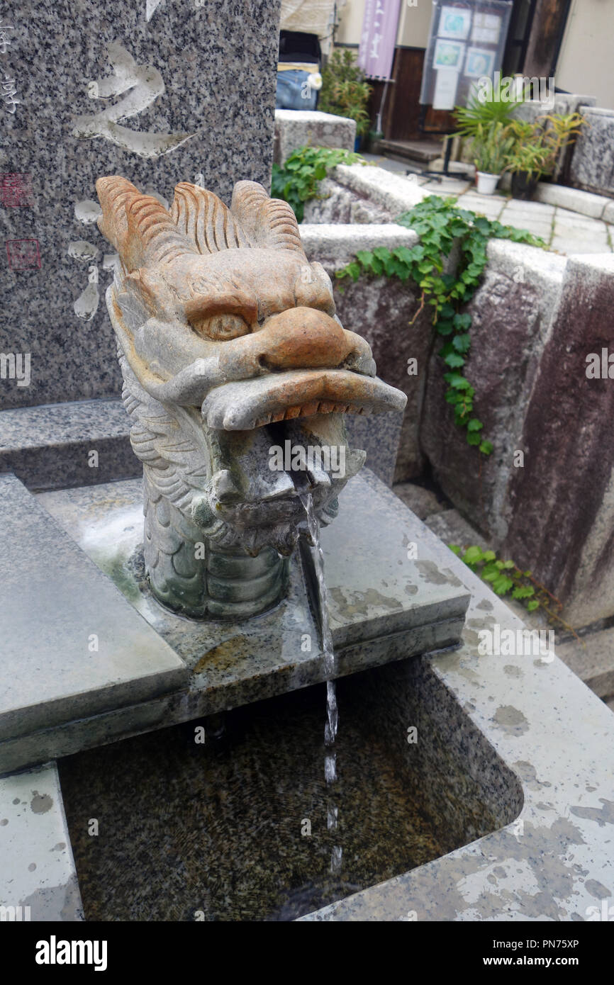 Stone testa di drago sgorga acqua sorgiva calda per i visitatori, Bessho Onsen, Prefettura di Nagano, Honshu, Giappone. N. PR Foto Stock