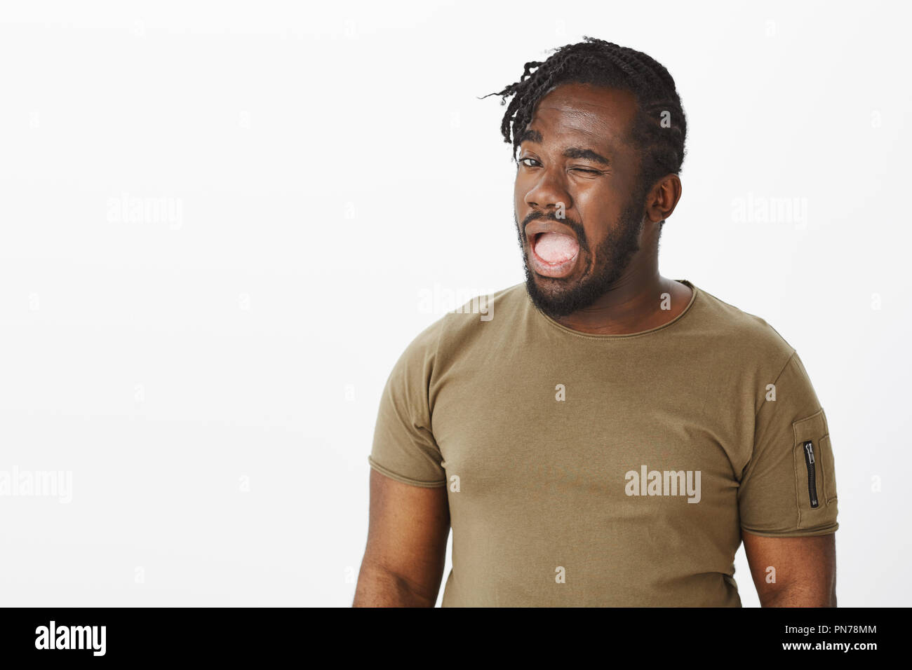 Se sai cosa voglio dire. Ritratto di intrigante divertente afro-americani in t-shirt casual, winking con bocca aperta, facendo accenno ed essendo in stato d'animo gioioso, concordando con un amico per fare qualcosa Foto Stock