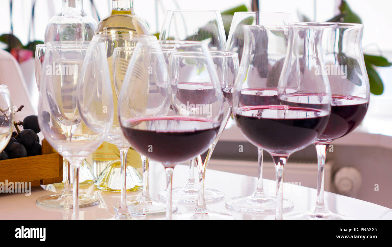 Vino rosso. Il vino. Bottiglia e bicchiere di vino rosso e bianco con uve mature ancora in vita. Foto Stock
