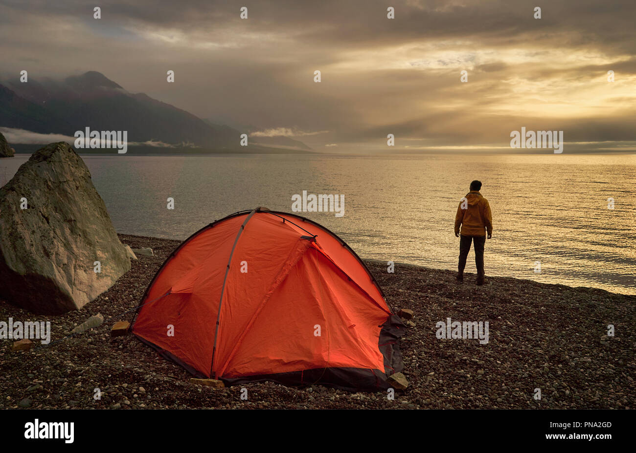 Escursionista guardando il bellissimo lago di sunrise vicino a Orange tenda. Foto Stock