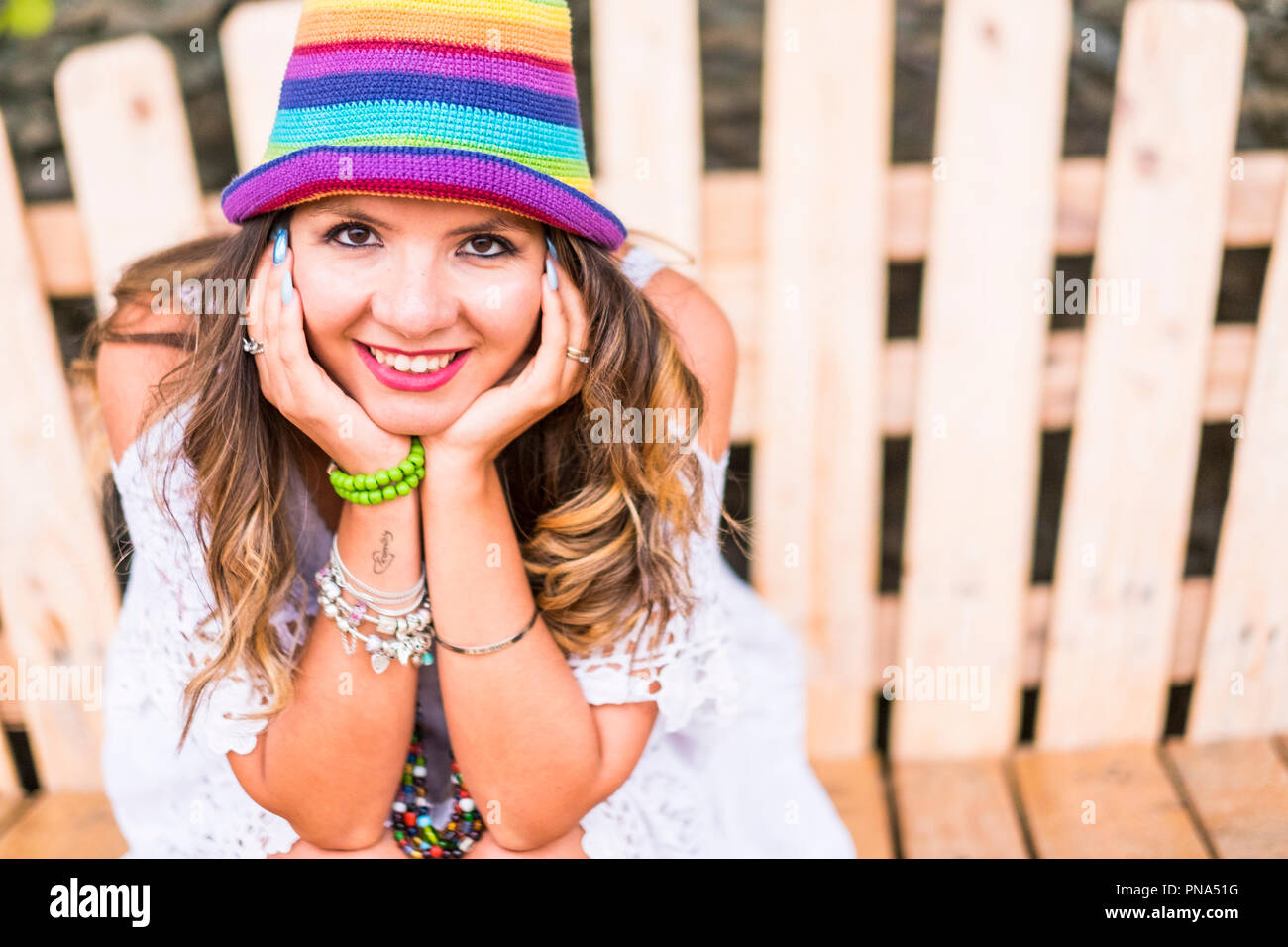 Ritratto di una bella caucasian allegro giovane donna in posa e sorridente alla telecamera. cappello colorato e fashion concept con modello di cute sorriso a voi. Foto Stock