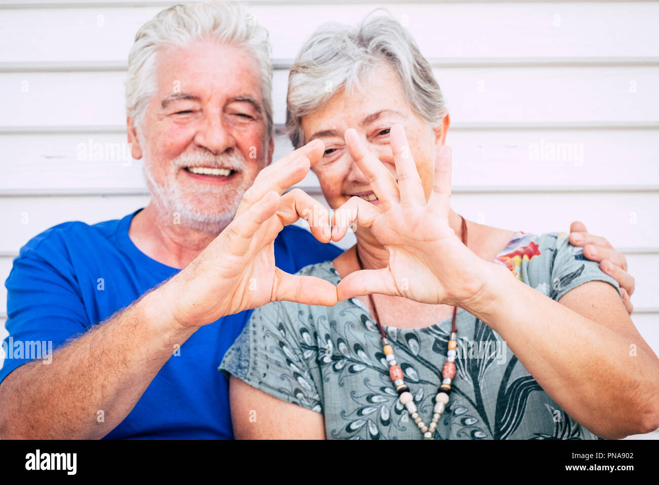 Giocoso bella allegro caucasica senior adulto giovane godendo di uno stile di vita con toghetner sorridere e ridere facendo cuore con le mani. amore e partnershi Foto Stock