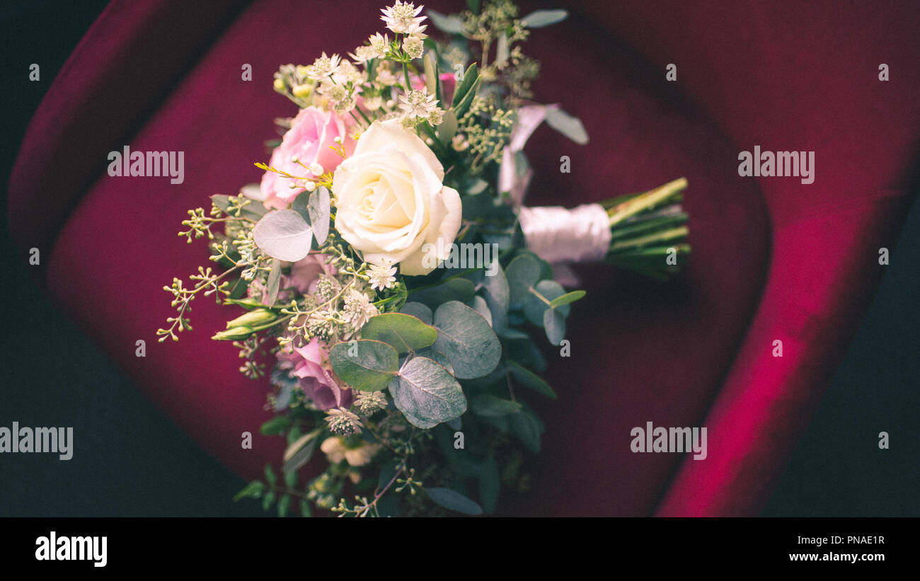 Bouquet di rose rosse sulla sedia di velluto Foto Stock