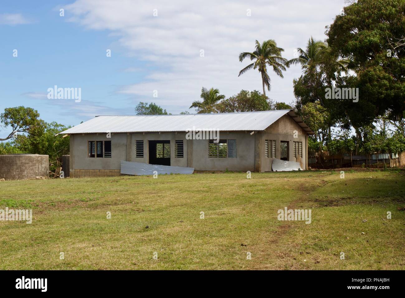 Edificio incompiuto di una comunità hall con un tetto ondulato in un villaggio nel Regno di Tonga Foto Stock