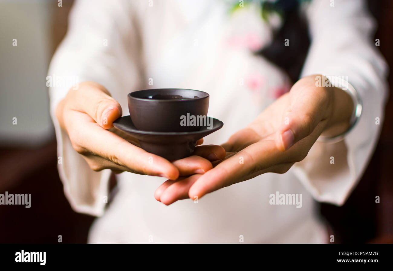 Donna che serve tè cinese in una tradizionale cerimonia del tè Foto Stock