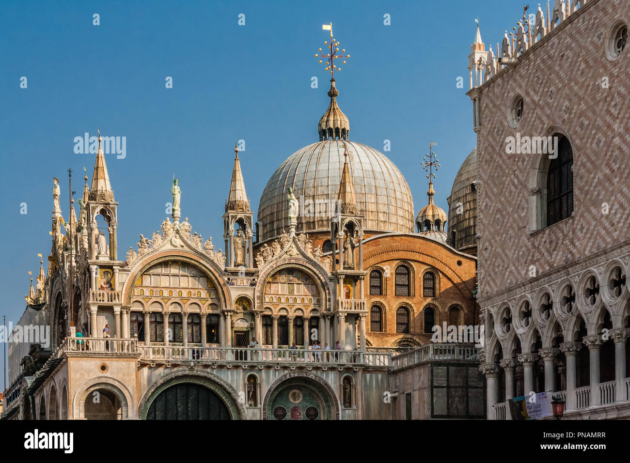 L'architettura unica di la Basilica di San Marco, Venezia, con turisti sul balcone. Foto Stock