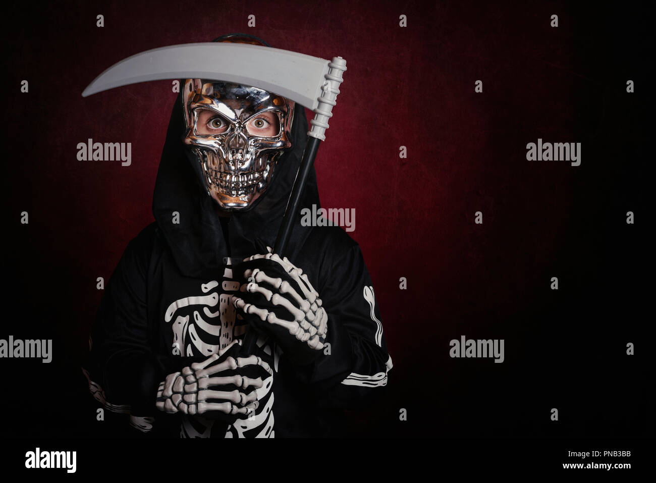 Ragazzo in costume scheletro su sfondo rosso Foto Stock
