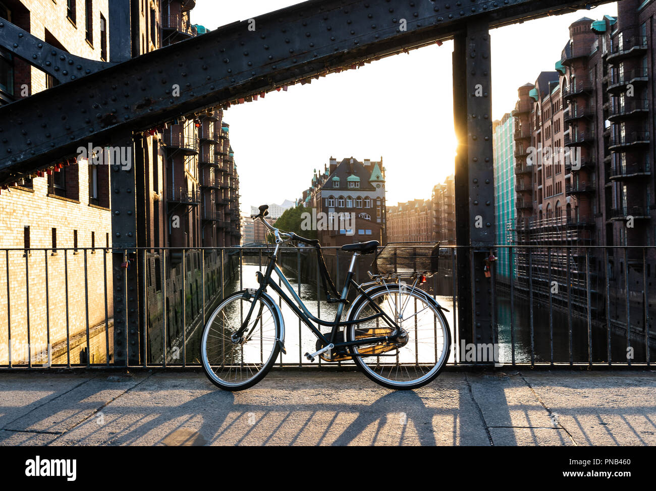 Bicicletta parcheggiata sul ponte al di sopra dell'acqua aganst cityscape di Amburgo Foto Stock