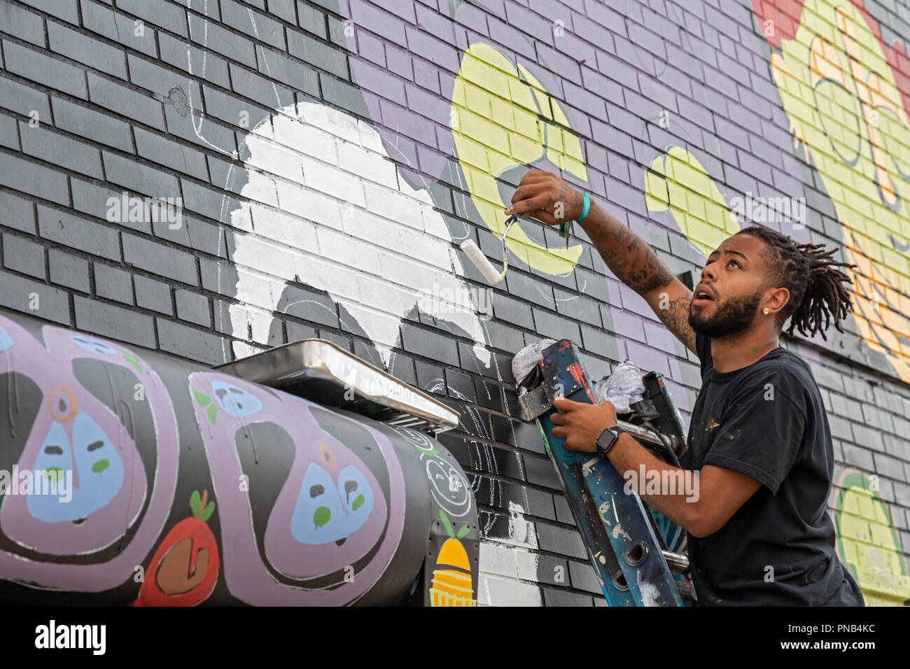 Detroit, Michigan - Tony Whlgn dipinge una parete durante il murales annuale nel mercato public art festival di Detroit orientale del quartiere del mercato. Foto Stock