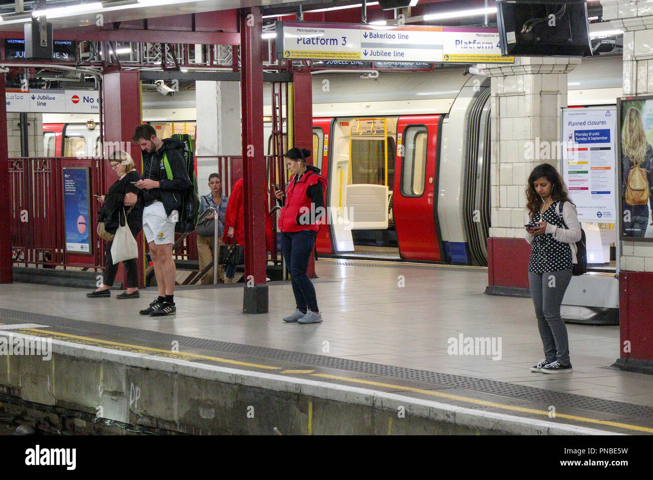 I passeggeri in attesa per il treno, la metropolitana di Londra, Inghilterra, Regno Unito Foto Stock