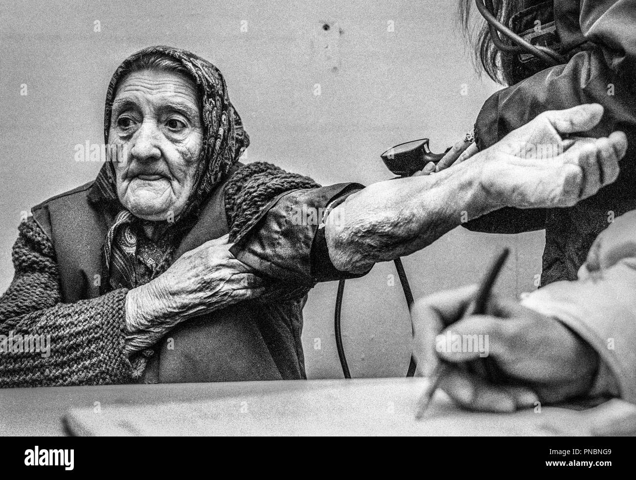 Nel gennaio 1998, ho avuto la fortuna di accompagnare un piccolo gruppo di Médecins Sans Frontières (Medici senza frontiere) come loro svolto il loro lavoro in Bosnia ed Erzegovina. Nonostante il fatto che questo era di due anni dopo la guerra aveva terminato le immagini ancora raffigurato un paese lacerata dalla guerra. Un MSF team mobile a effettuare il cambio con i medici in chirurgia Ostrovo, Croazia. MSF curativo fornito assistenza sanitaria per gli anziani e le popolazioni vulnerabili in 12 villaggi remoti nella regione fino al marzo 1998.I pazienti erano principalmente Serbi anziani. Donna anziana avente la pressione del sangue preso da infermieri. Foto Stock