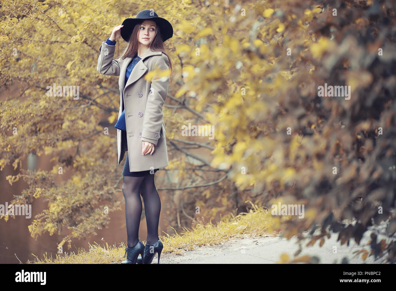 Giovane ragazza in un cappotto in autunno park Foto Stock