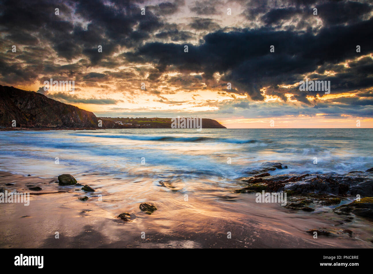 Tramonto sulla spiaggia di Tresaith in Ceredigion, Galles, guardando verso Aberporth. Foto Stock