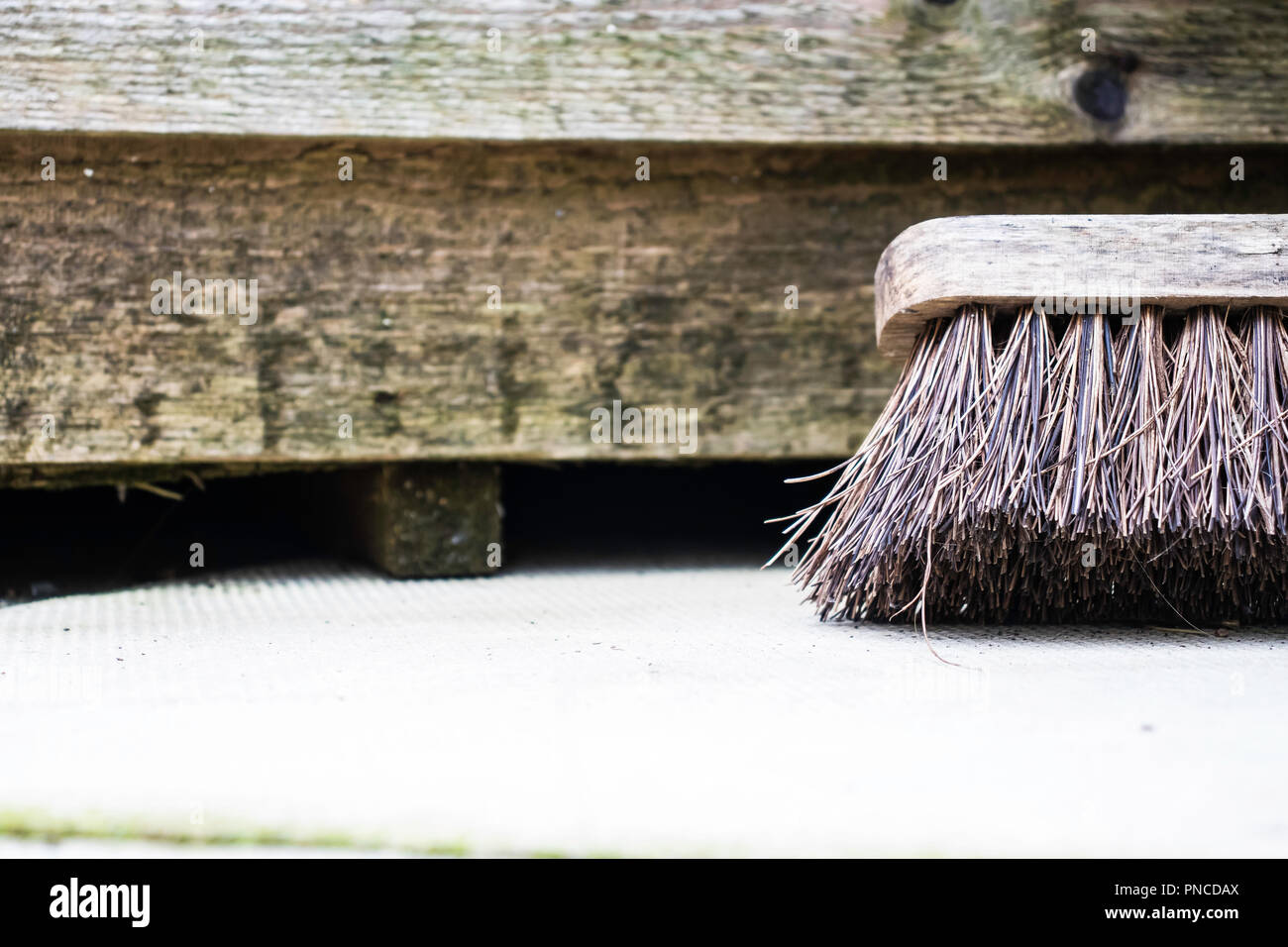 Close up garden broom appoggiata contro la tettoia in legno Foto Stock