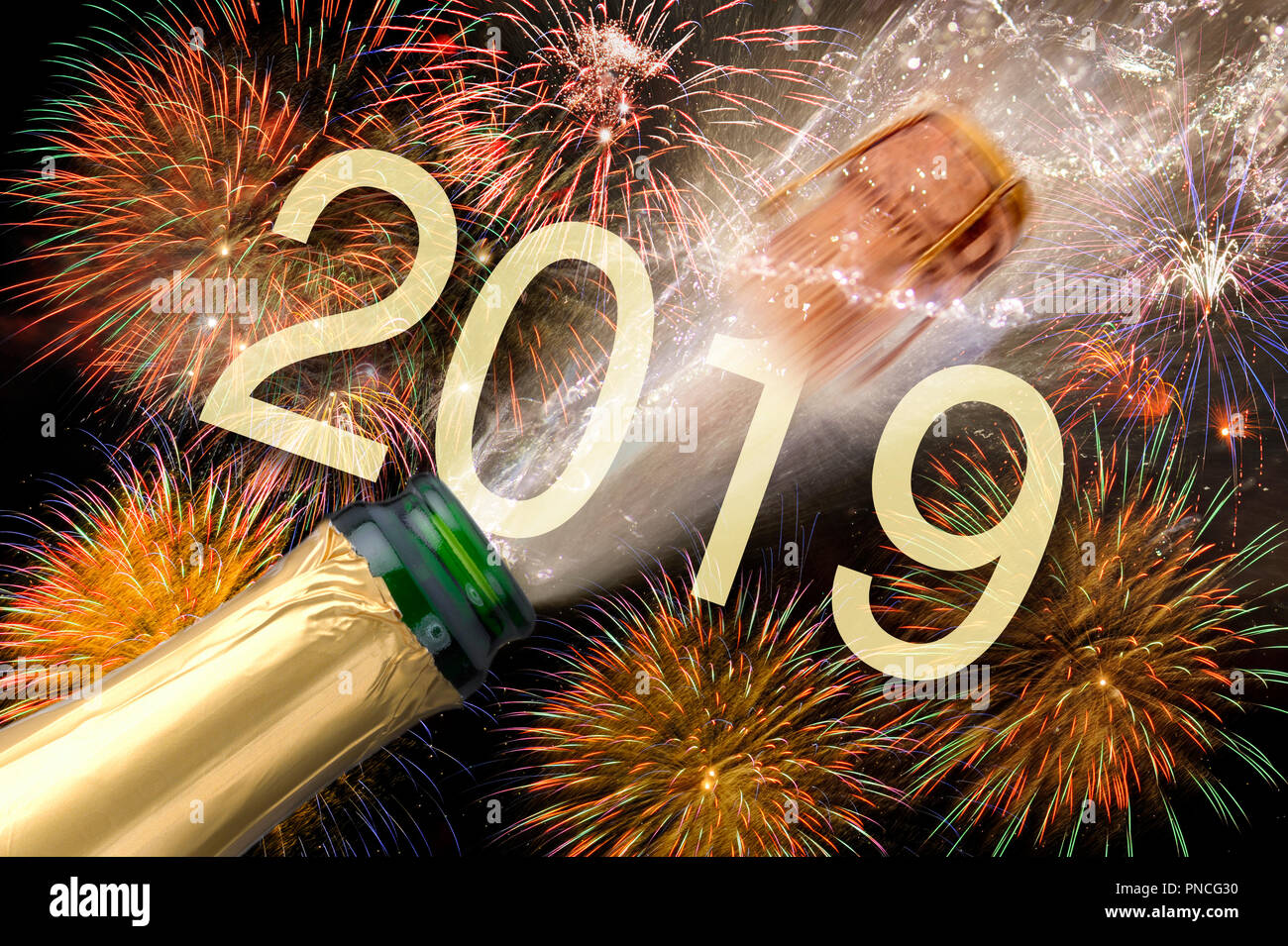 Gli spruzzi di una bottiglia di champagne con battenti sughero e fuochi d'artificio a Silvestro 2019 Foto Stock