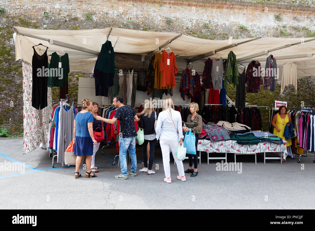 People shopping per i vestiti nel mercato di Siena, Siena, Toscana Italia Europa Foto Stock