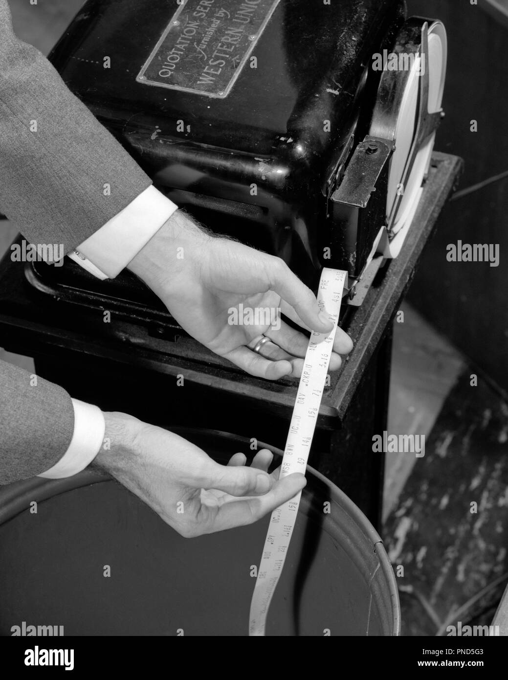 Anni Cinquanta anni sessanta mani maschio azienda preventivo Stock Ticker tape emergente dalla macchina - o1373 HAR001 HARS scoperta opportunità occupazioni connessione Stock Trader quotazione investitore emergente mercato azionario in bianco e nero di etnia caucasica mani solo HAR001 in vecchio stile Foto Stock