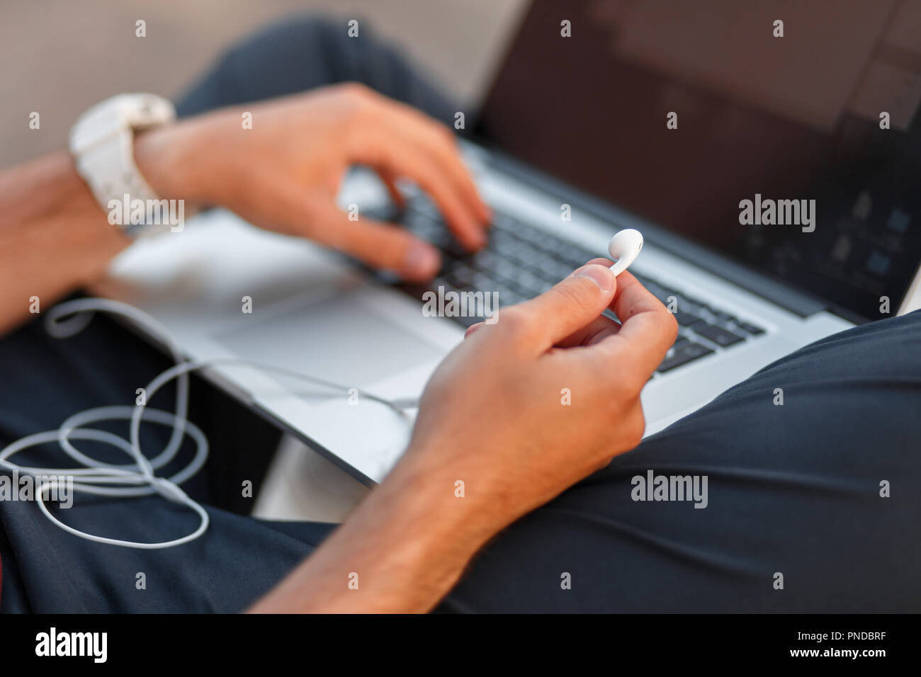 Imprenditore blogger uomo con un auricolare e di lavorare su un laptop. Close-up Foto Stock