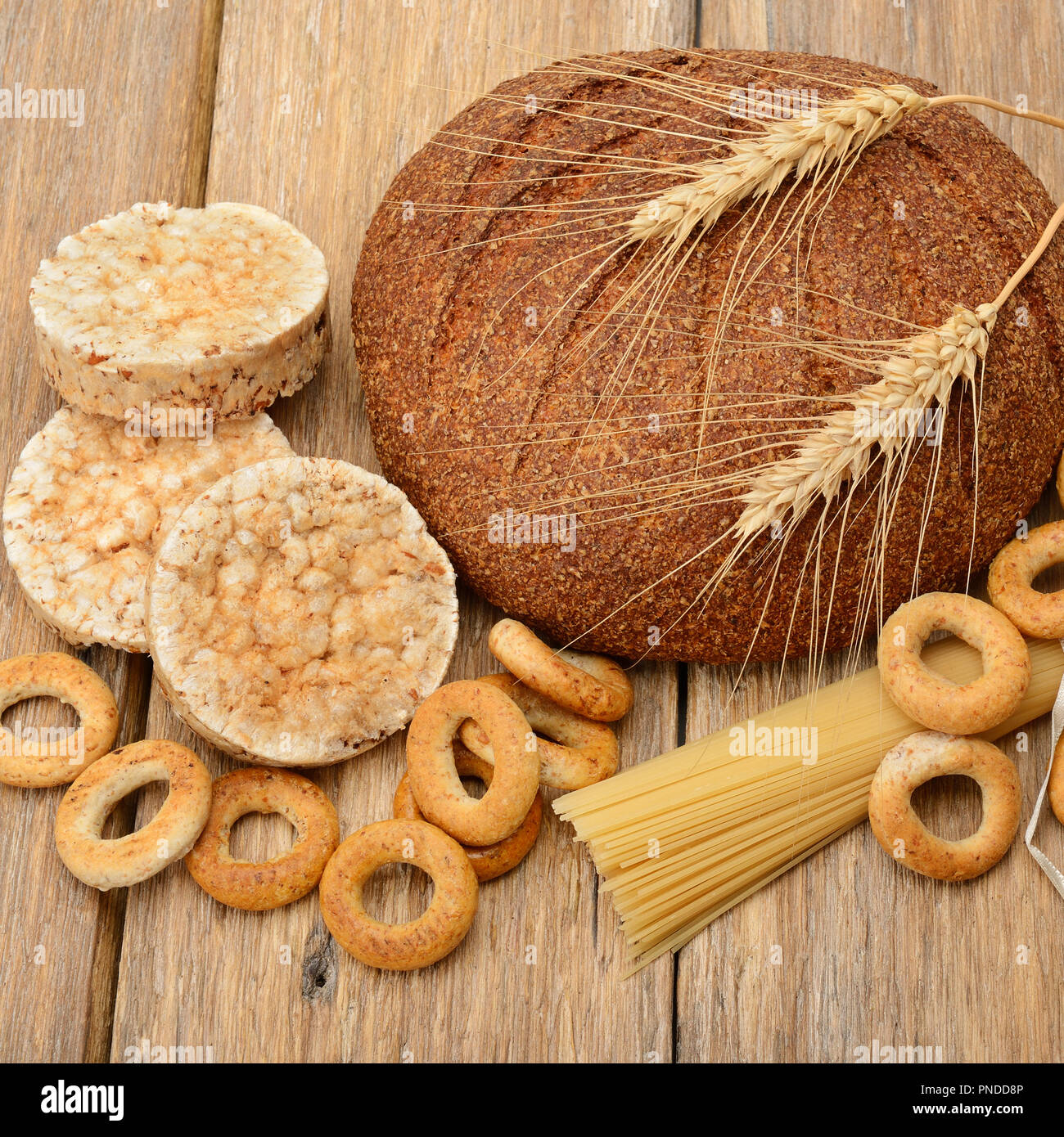 Pane, pasta e pasticceria su una superficie in legno Foto Stock