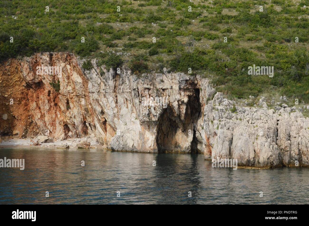 Scogliere rocciose con piccole grotte presso la costa in Istria in Croazia il colpo da una barca Foto Stock