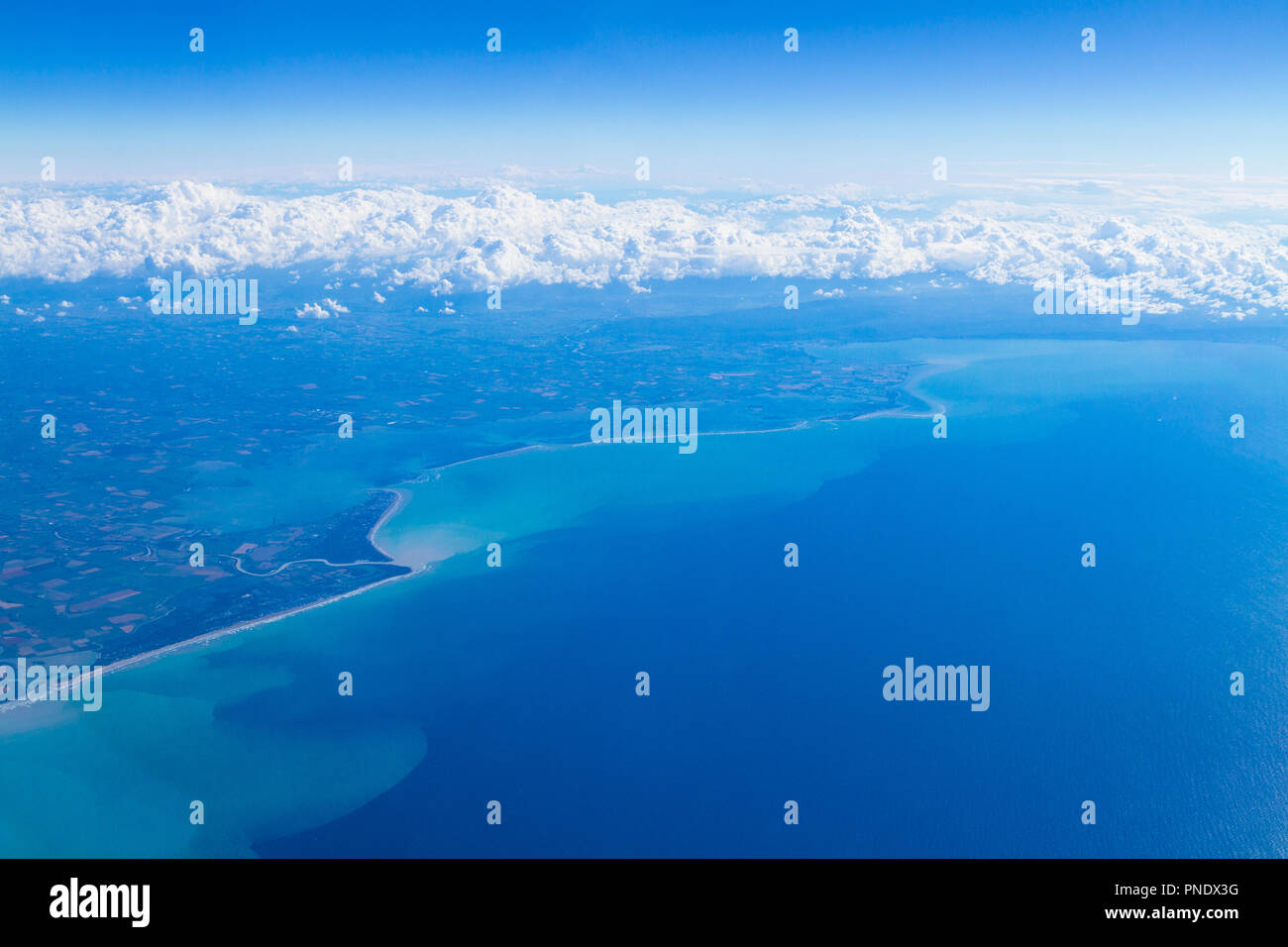 Vista aerea di corpi unici di cumulus temporale nuvole sulla laguna di Venezia e il golfo di Trieste visto attraverso una finestra di aereo. Foto Stock