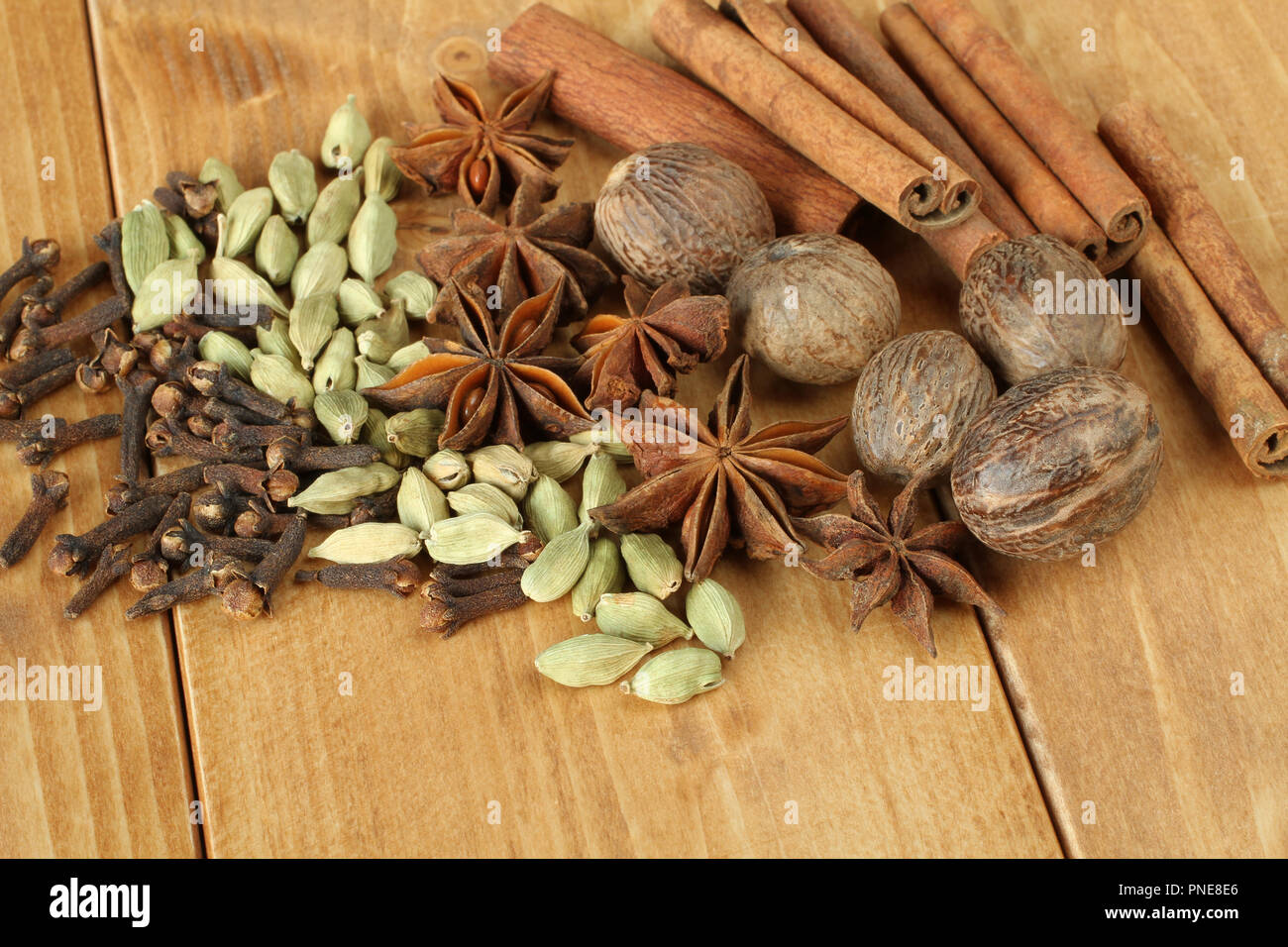 Pila di spezie a secco i chiodi di garofano, il mucchio di asciugare sparse in oli di semi di cardamomo, mazzetto di secco di spezie anice, essiccato noce moscata frutta secca, bastoncini di cannella, giacente su Foto Stock