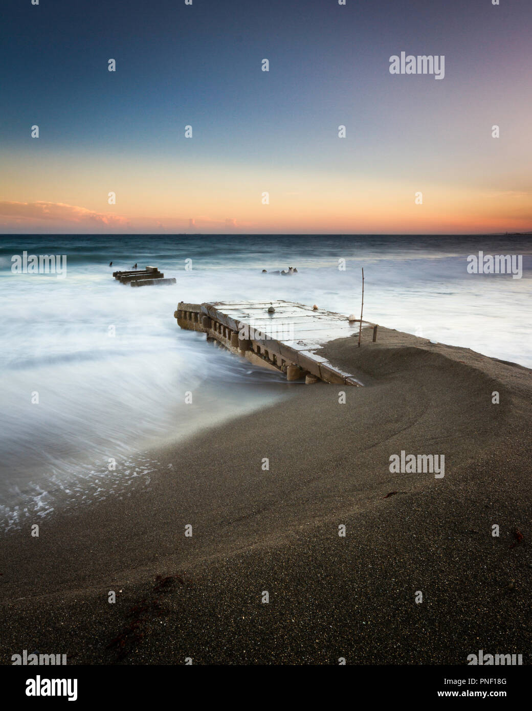 Seascape di un vecchio molo al tramonto Foto Stock