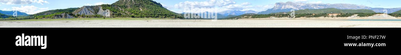 Un paesaggio verde del mediano del lago artificiale in spagnolo Pirenei aragonesi come visto dall'interno del lago, con verde erba fresca, Spagna Foto Stock