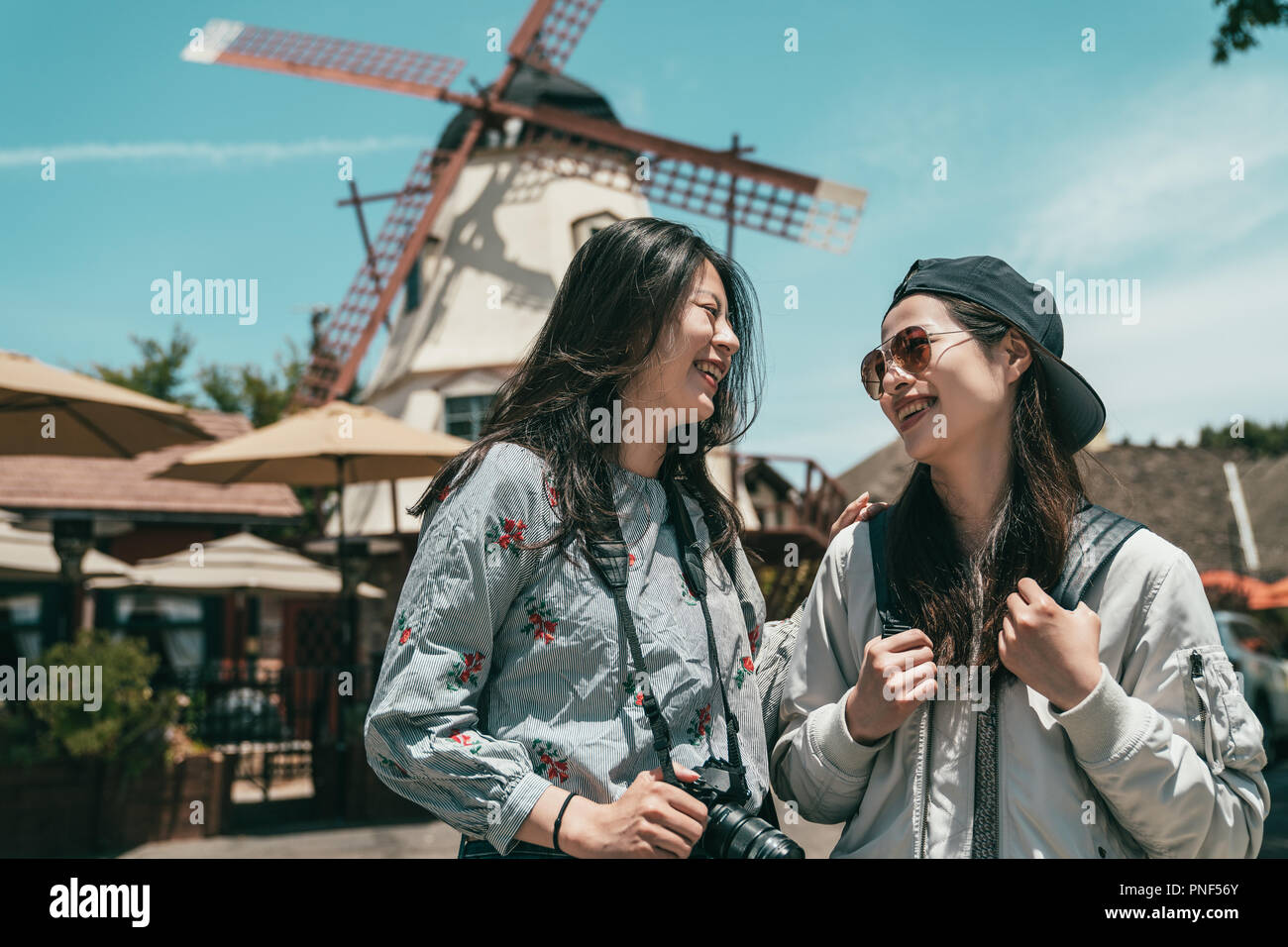 Due belle sorelle ridere gli uni con gli altri mentre per scattare delle foto e di visitare una città bellissima. Foto Stock