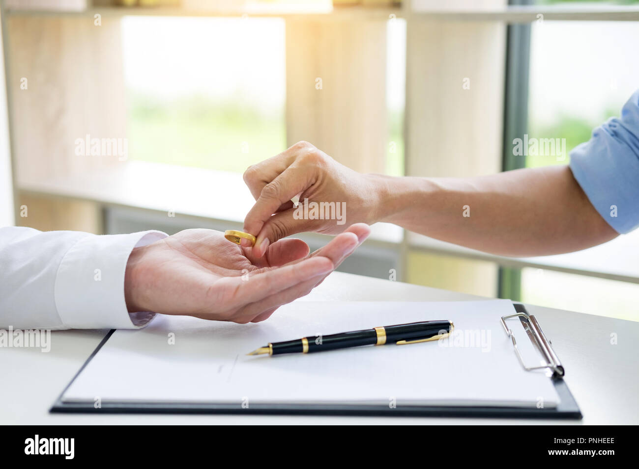 Le mani della moglie, marito firma il decreto di divorzio, dissoluzione, annullamento di matrimonio, divorzio lfiling carte o accordo prematrimoniale preparata da un avvocato. Foto Stock