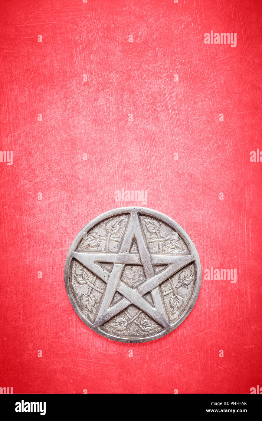 Siver pentagram su una texture di sfondo rosso. Pentagramma per wicca wiccan cerimonia e rituali spirituali Foto Stock